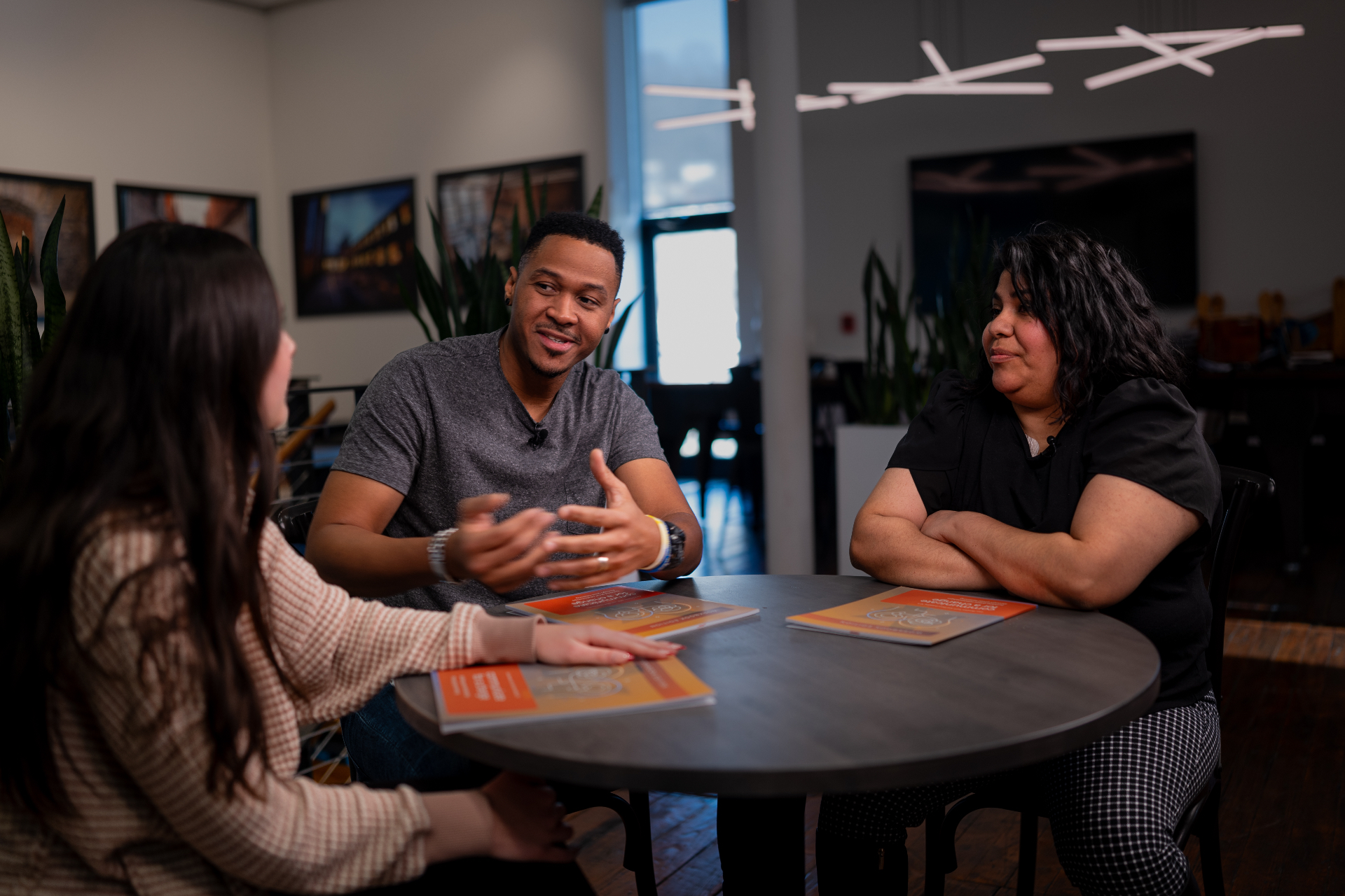 Three people in warm, engaged conversation around a small table